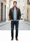 Man wearing stylish brown leather jacket, blue tee, and dark jeans for urban casual look