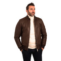 Men's brown leather bomber jacket with ribbed cuffs, styled over cream turtleneck for modern casual wear