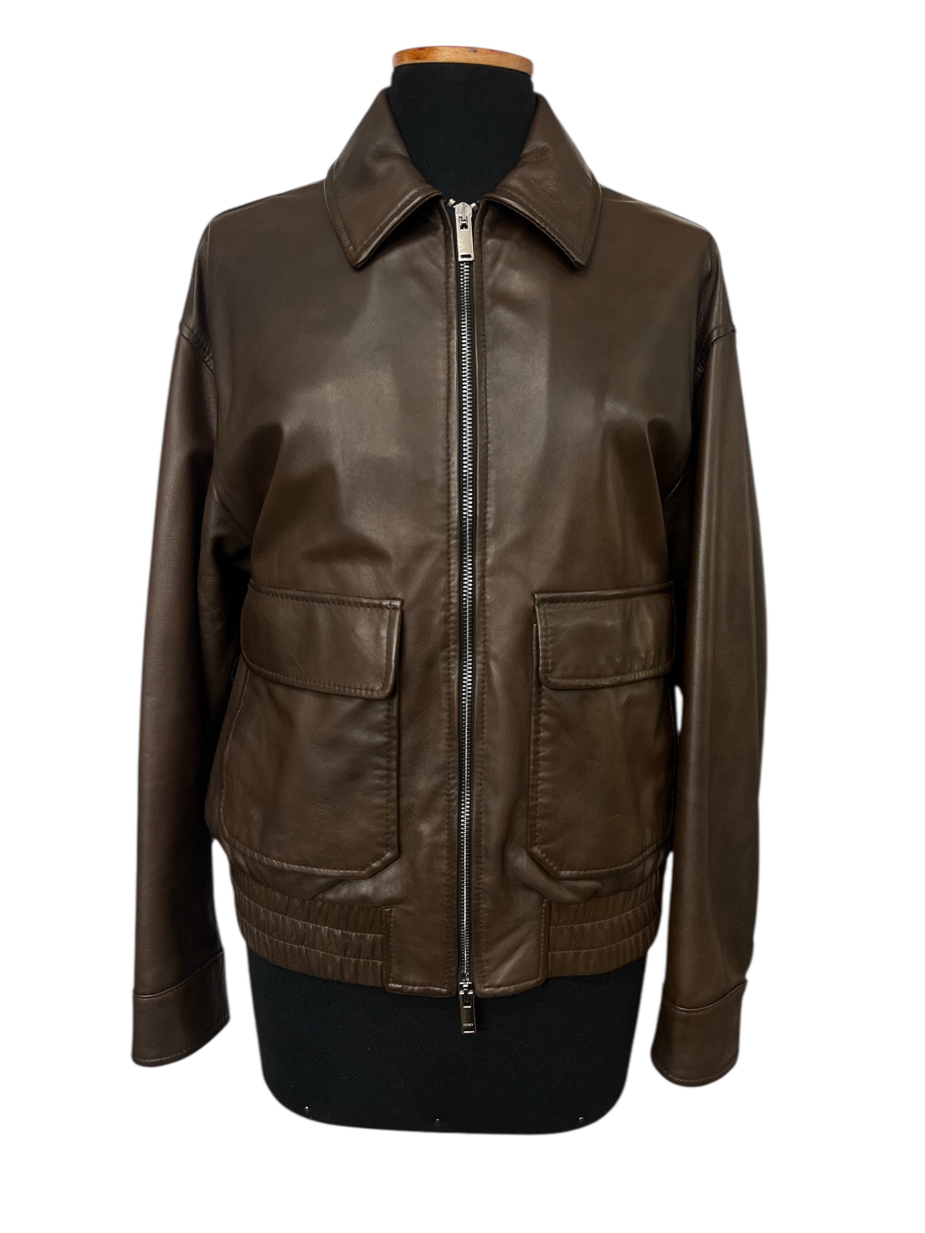 Brown leather jacket with front zipper and two pockets, displayed on mannequin