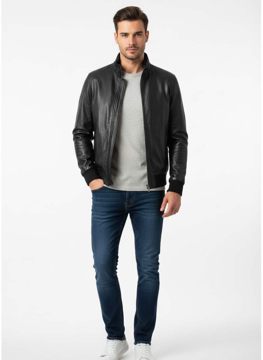 Man wearing a black leather jacket, gray shirt, and blue jeans on a white background